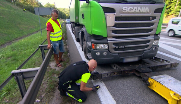 Autokar na dużym rondzie i ciężarówka na estakadzie